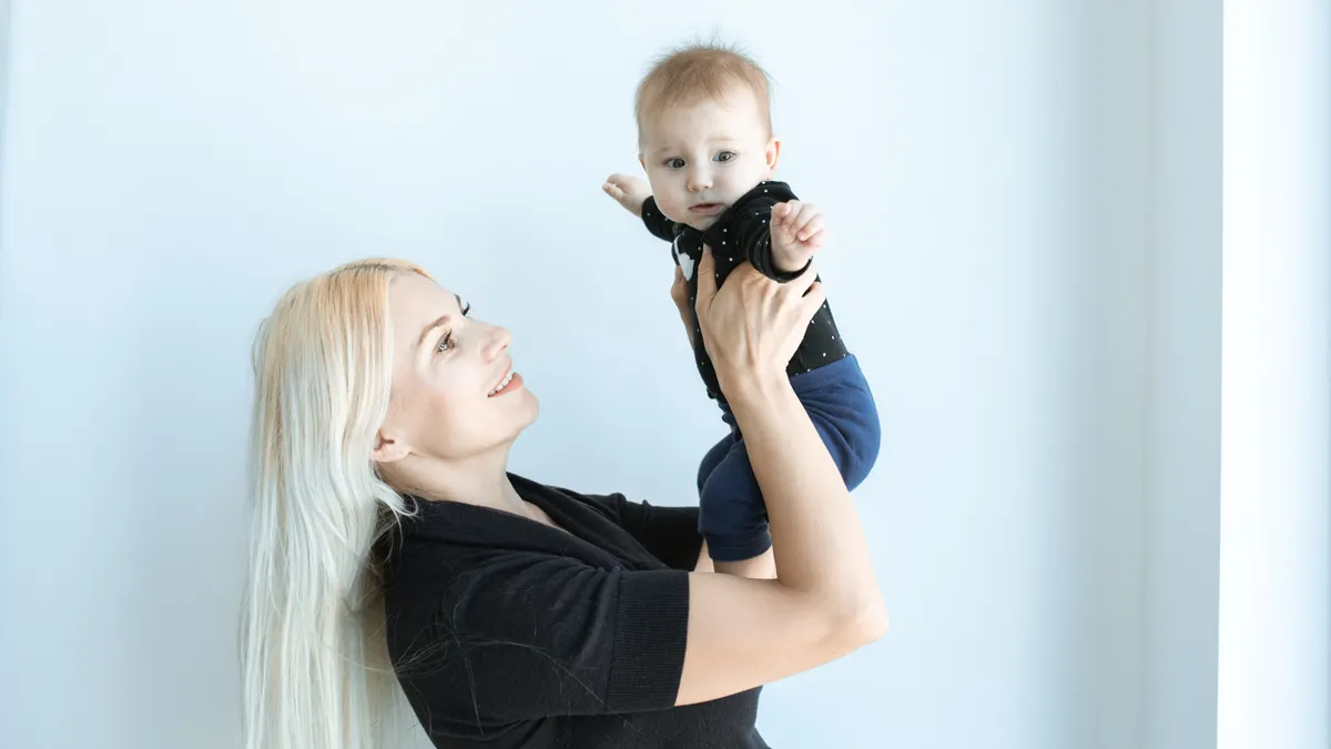 Woman holding a baby up indoors
