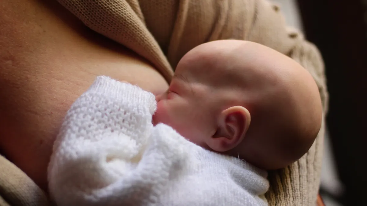 How to pump breast milk: a beginner's routine for new parents Close-up of a baby nursing at the breast