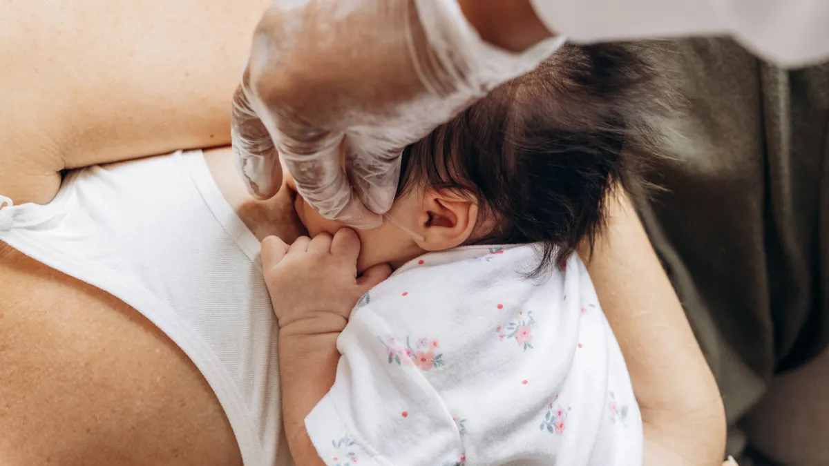 How to tell if your baby is getting enough milk Baby latched at the breast in a close embrace